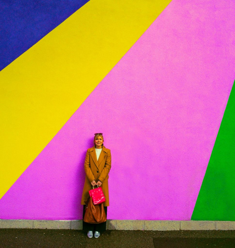 Sarah Oecken standing by a colourful wall